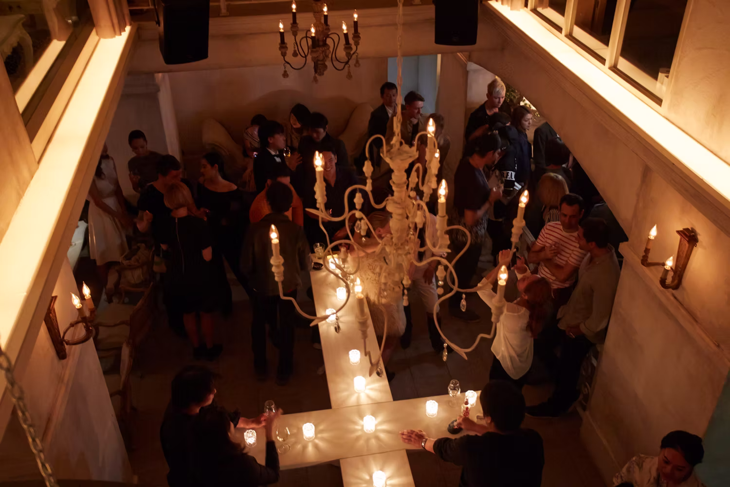 The floor seen from above, chandeliers and candles over a full room
